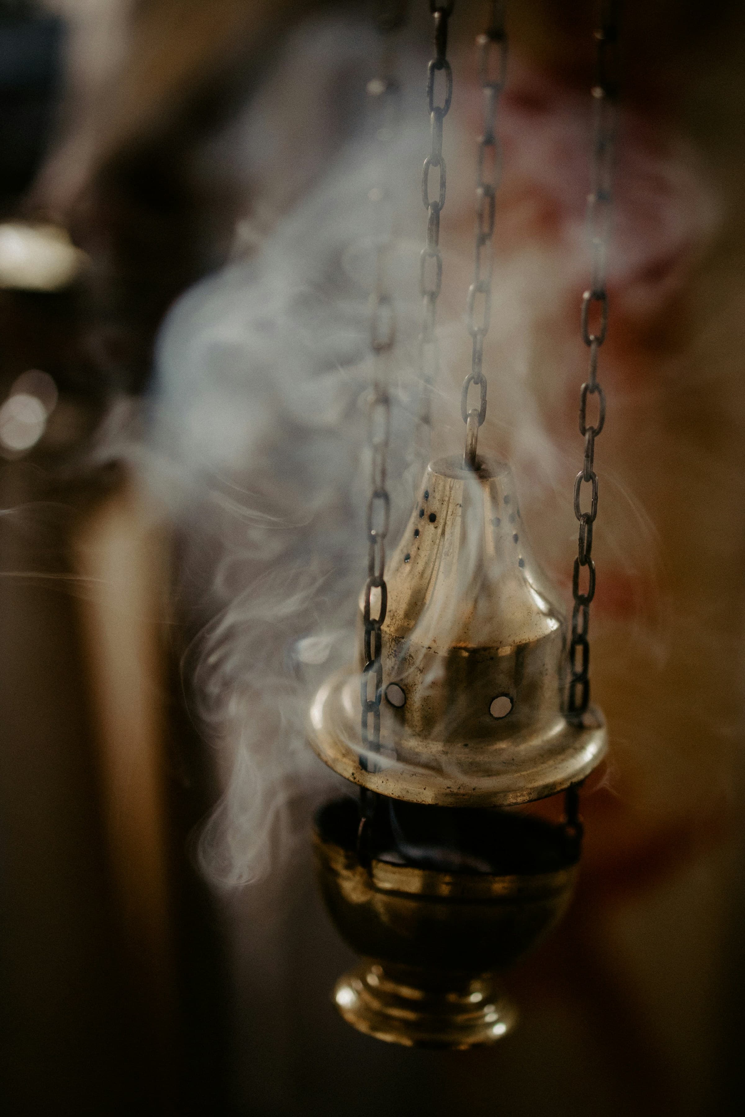 Smoke rising around a brass incense burner